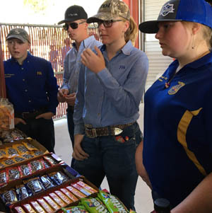 Adults and students standing in front of a candy fundraiser table