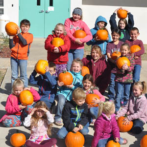 Students holding pumpkins