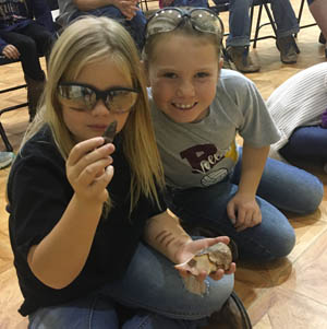 Two students looking closely at a small object