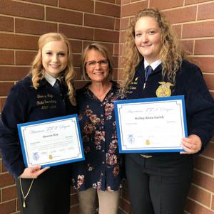 Two students holding certificates with an adult